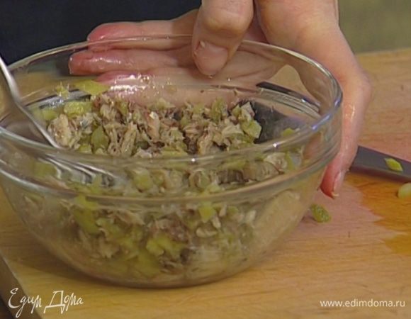 Шпроты выложить из банки (масло сохранить), размять вилкой и перемешать с корнишонами и оливками.