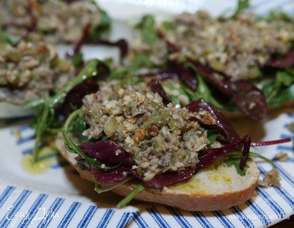 Хлеб нарезать, сбрызнуть маслом, оставшимся от шпрот, выложить на каждый кусок немного салата, 1 ч. ложку шпротной массы и присыпать орехами.