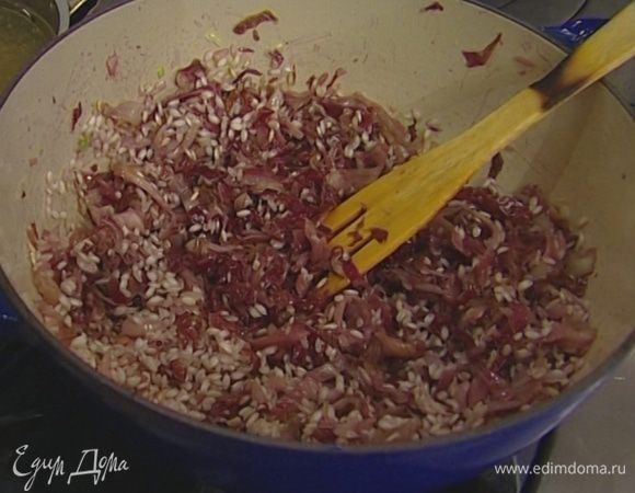 Добавить чеснок, всыпать рис, перемешать и подержать 2–3 минуты на огне, пока рис не станет прозрачным, затем влить половину белого вина и дать ему немного выпариться.