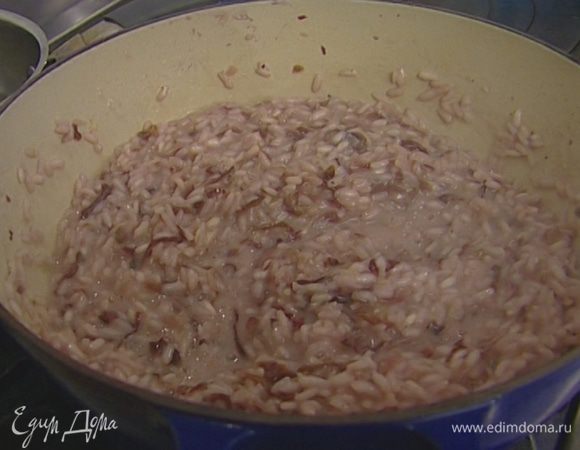 Постепенно, половник за половником, добавлять предварительно разогретый куриный бульон, постоянно помешивая и следя за тем, чтобы рис не плавал в жидкости, а впитывал бульон. Держать на огне в течение 15 минут.