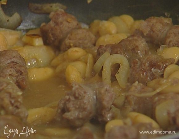 Отправить в сковороду к фасоли обжаренные колбаски, влить оставшееся вино и тушить на медленном огне еще 10 минут.