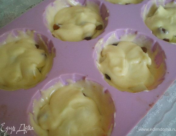 Яблоки нарезать кубиками. В формочки налить немного теста, выложить яблоки и изюм, и снова залить тестом. Выпекать в разогретой духовке 35 минут. 