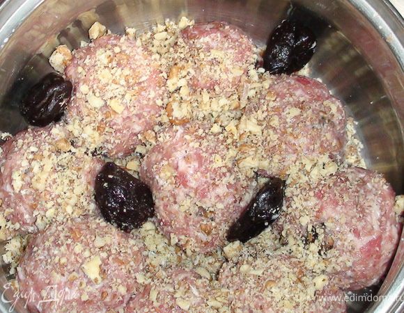 Сформировать тефтельки и уложить их в кастрюлю. Посыпать оставшимися орехами и положить чернослив.