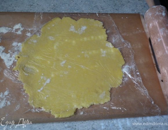 Берем одну половину теста и раскатываем на посыпанной мукой бумаге для запекания в форме круга 24см. Чтоб не прилипало к скалке, можно сверху положить пленку.