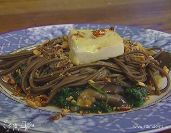 На тарелку выложить грибы со шпинатом, лапшу, сверху поместить обжаренное тофу, посыпать все измельченными орехами и полить заправкой.