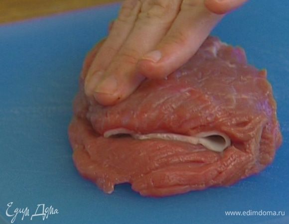 Завернуть в ветчину немного сыра, уложить внутрь отбивной и скрепить карман зубочисткой. 