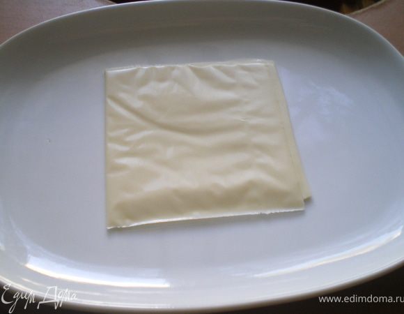 На тарелку положить ломтик плавленного сыра.