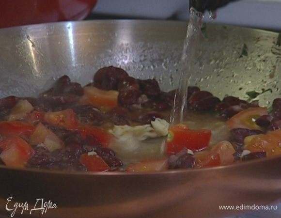 Добавить в сковороду нарезанные помидоры, растертый чеснок, щепотку перца, оставшееся вино и прогревать на небольшом огне.