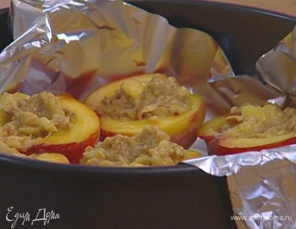 Выстелить фольгой глубокую форму для выпечки, уложить в нее половинки персиков и наполнить их начинкой.