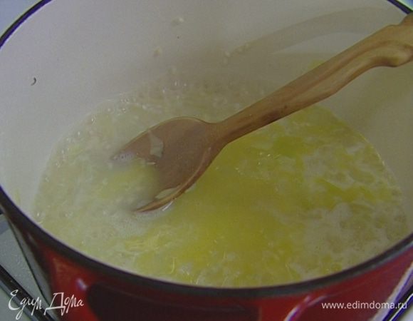 Добавляя понемногу подогретый бульон, готовить ризотто на медленном огне около 18 минут, все время помешивая.