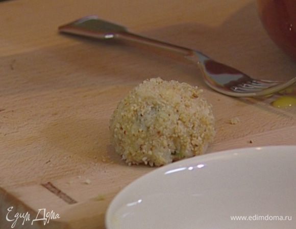 Добавить в готовое ризотто моцареллу, пармезан и зелень, перемешать, остудить и сделать из него небольшие шарики — бомбы.