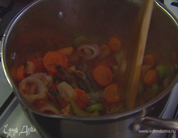 Отправить в кастрюлю с овощами половину консервированных помидоров вместе с соком и все прогреть, затем добавить креветок и кальмаров и тушить еще несколько минут.