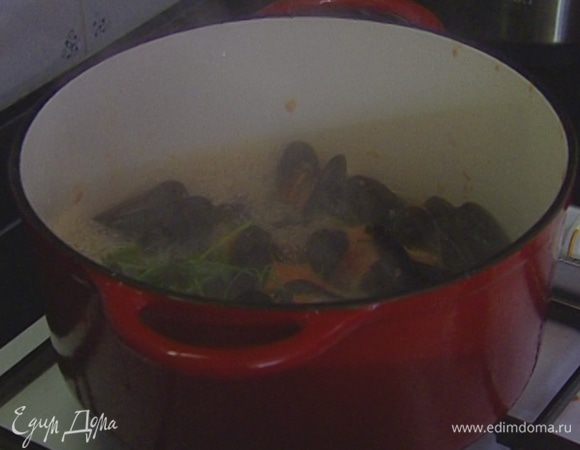 В тяжелой кастрюле большего размера разогреть 1 ст. ложку оливкового масла, выложить оставшиеся помидоры с соком, чеснок и петрушку. Добавить мидии, влить вино и 125 мл горячей кипяченой воды. Когда вода закипит, накрыть крышкой и готовить 5‒7 минут.
