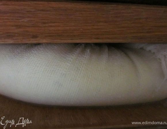 Затем завязать концы марли, выложить сыр на доску, накрыть другой доской и поставить пресс часа на 4-5. Я ставила 5-литровую канистру с водой. 