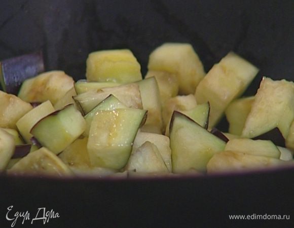 Разогреть в сковороде вок растительное масло и обжаривать баклажаны 10–15 минут, постоянно помешивая.