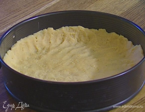 Охлажденное тесто выложить в разъемную форму для выпечки, равномерно распределить его, проткнуть в нескольких местах вилкой и застелить бумагой для выпечки. 