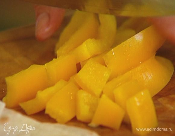 Сладкий перец разрезать пополам и, удалив плодоножку с семенами, нарезать мякоть кубиками. 