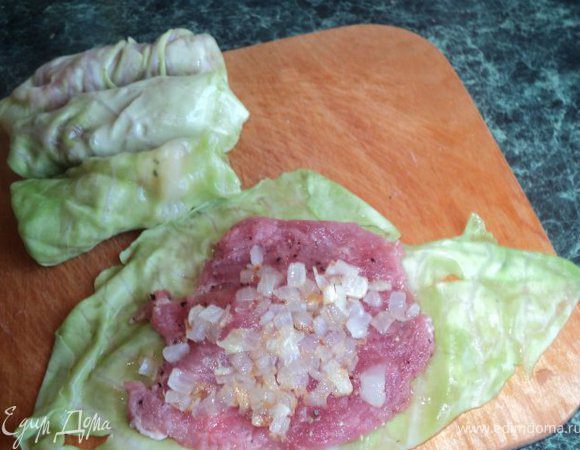 На лист капусты положить отбивную, сверху немного лука и свернуть голубец. 