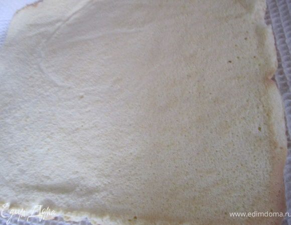 Перевернуть бисквит на полотенце, немного присыпанное сахаром.
Снять пергаментную бумагу.
Аккуратно свернуть в рулет.