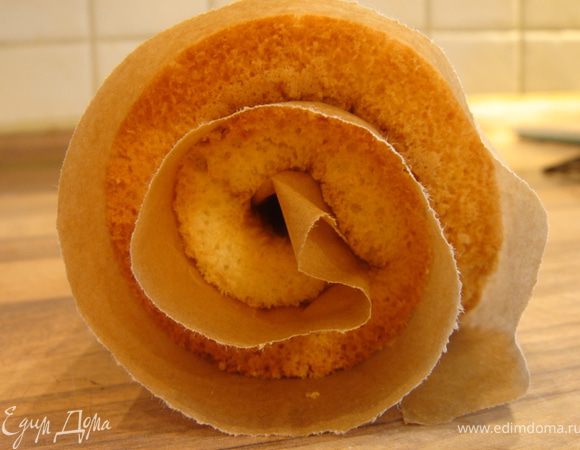 Аккуратно провести лопаткой между бисквитом и бумагой.Затем завернуть бисквит в рулет.