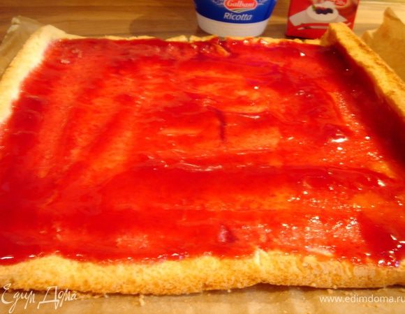 Сливки с сахарной пудрой хорошо взбить.Рикотту размять вилкой и аккуратно смешать со сливками.Отложить 2-3 ст.л. крема для украшения.Развернуть рулет и снять бумагу.Промазать бисквит 3ст.л.джема.Затем промазать кремом и аккуратно свернуть бисквит в рулет.Украсить отложенным кремом,джемом и свежими ягодами.Охладить рулет в холодильнике.Приятного аппетита!