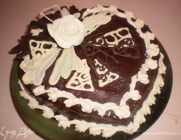 Остывший торт украшаем шоколадными завитушками, мастичной розой, делаем из крема бордюр.