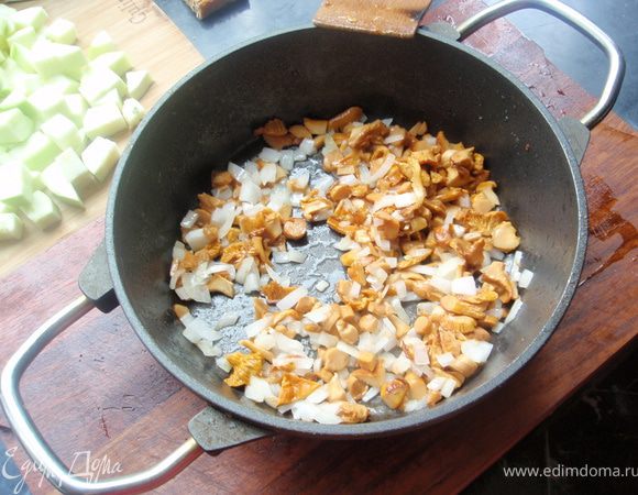 В сотейник отправляем лисички. Когда выпариться вся влага из грибов, добавим немного масла и лук. И дадим подрумяниться.