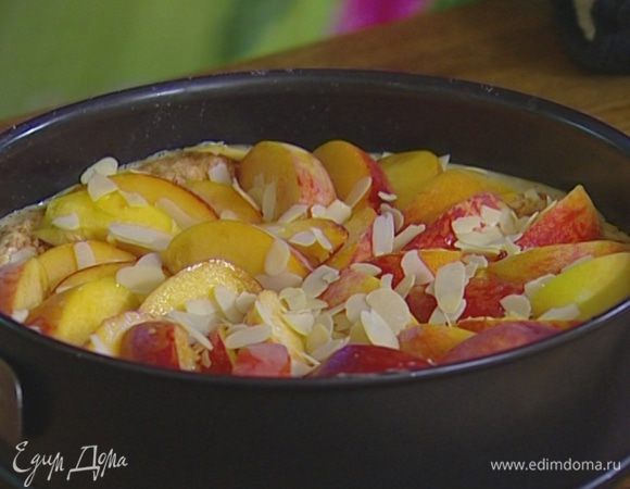 Остывший корж присыпать половиной миндальной крошки, выложить крем, присыпать оставшейся крошкой. Уложить на крем как можно больше персиков.