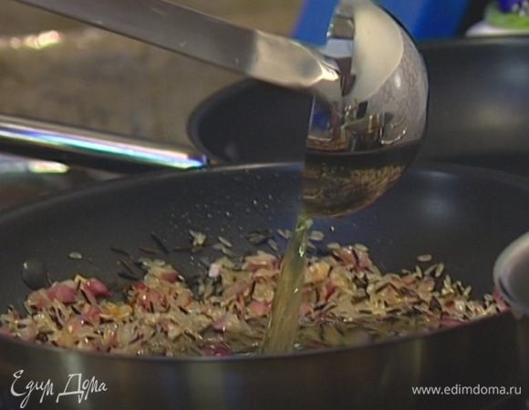 Всыпать рис, влить вино и перемешивать все вместе в течение минуты.