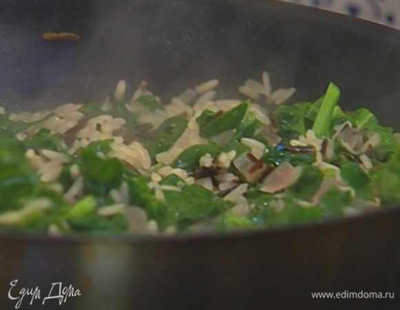 Снять рис с огня, добавить листья базилика, пармезан и все перемешать.