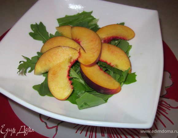 Нарезать персики крупными кусочками и разбросать на листья