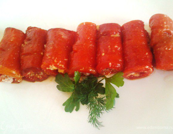 Выложить смесь из пармезана на каждый кусочек перчика, закрутить рулетики. Подровнять края, выложить, украсить зеленью.