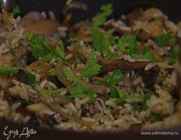 Выложить в сковороду отваренный рис, перемешать, затем добавить рубленую петрушку.