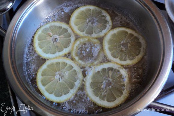 На сковороду положить 5ст. ложек сахара и немного воды, сварить сироп, в котором проварить по 3-4мин дольки лимона и апельсина. Готовые дольки выложить на сито, дать стечь сиропу, разрезать на половинки.