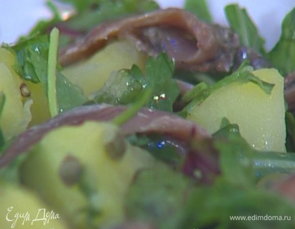 Перемешать руколу с картофелем, сверху разложить филе анчоусов.