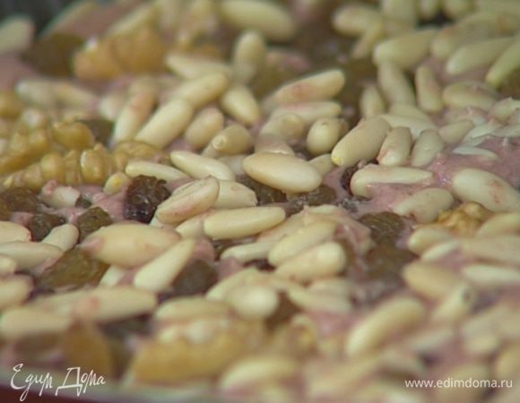 Сверху на тесто, слегка вдавливая, выложить орехи, изюм и розмарин.