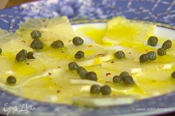 Кружки лимона выложить на тарелку, присыпать каперсами, сбрызнуть оливковым маслом и посыпать перцем чили.