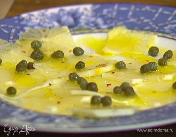 Кружки лимона выложить на тарелку, присыпать каперсами, сбрызнуть оливковым маслом и посыпать перцем чили.