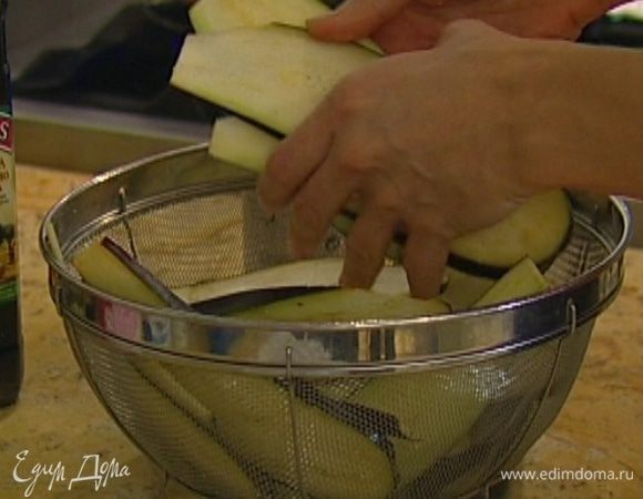 Баклажаны нарезать вдоль пластинами, выложить в дуршлаг, посыпать солью, перемешать и оставить на 20–30 минут, затем промыть холодной водой и просушить бумажным полотенцем.