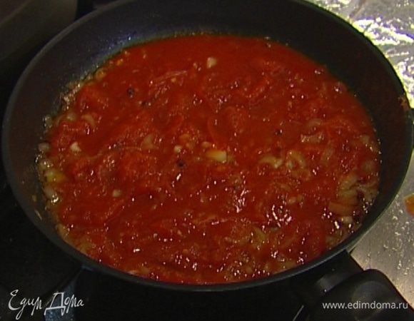 Приготовить соус: разогреть в сковороде 1 ст. ложку оливкового масла и обжаривать лук и чеснок около минуты, затем влить овощной бульон, всыпать сахар, соль и розовый перец, добавить помидоры вместе с соком, слегка размять их вилкой и томить все на медленном огне 10–15 минут.