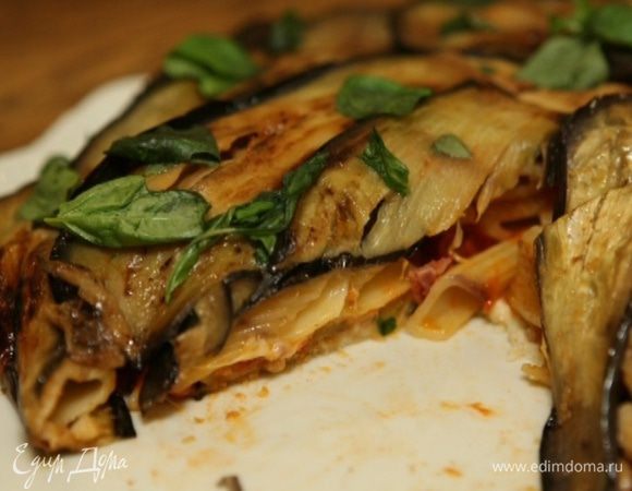 Готовый пирог перевернуть на тарелку, затем снять форму и фольгу. Листья базилика измельчить руками и посыпать пирог.