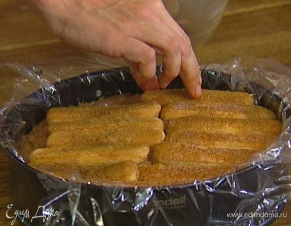 Круглую форму для выпечки выстелить пищевой пленкой. На дно формы уложить слой печенья, затем крем, сверху снова слой печенья. Затянуть сверху пленкой и поставить в морозилку минимум на 4 часа. 