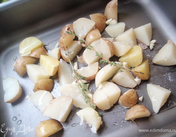 Отваренный картофель нарезаем на четвертинки. Выкладываем на противень, сбрызгиваем оливковым маслом. Добавляем раздавленные и крупно нарезанные дольки чеснока. Сверху веточки свежего тимьяна. Присаливаем. Я ещё добавила немного жировых прослоек с панчетты. И отправляем в духовку на 10 минут при температуре 200 градусов.