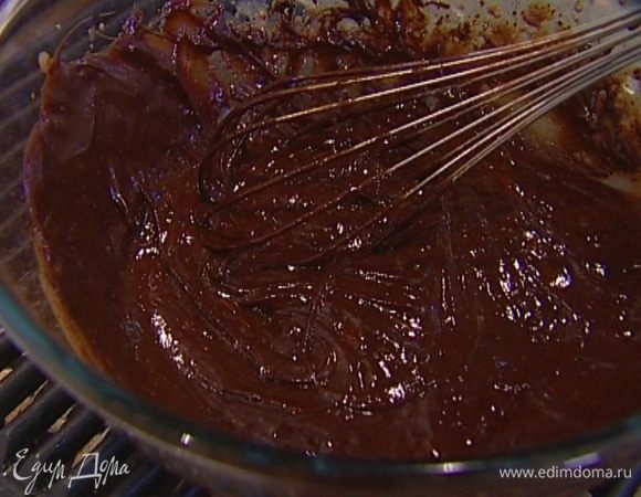 Ввести растопленный шоколад в сливочно-желтковую массу, снять кастрюлю с водяной бани, добавить 50 г предварительно размягченного сливочного масла и вымешать все венчиком.