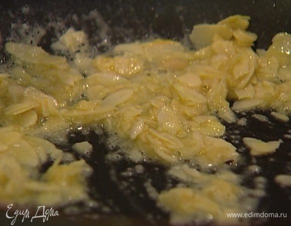 Растопить в сковороде 50 г сливочного масла, добавить оставшийся сахар и муку, молоко и миндальные хлопья. Помешивая, довести все до кипения. 