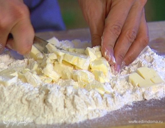 Приготовить тесто: муку просеять, добавить в нее 180 г предварительно охлажденного сливочного масла и порубить его кубиками вместе с мукой, затем растереть все вместе руками, чтобы получилась однородная крошка.