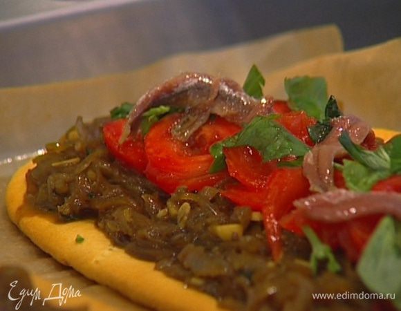 Равномерно распределяя, выложить на коржи обжаренный лук, ломтики помидоров, оставшиеся анчоусы, сверху присыпать оставшимися листьями базилика.