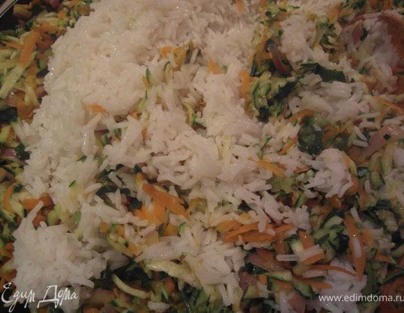 Снять сковороду с огня и переложить овощи в большую миску. Добавить рис. Дать 10 минут массе охладиться.