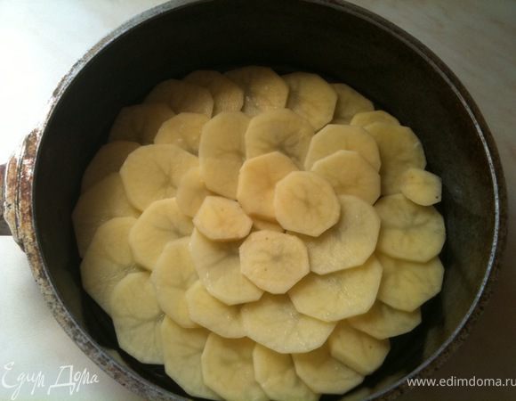 Дно формы смазать растительным маслом и выложить плотно дольки картофеля.