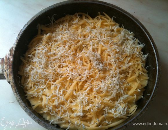 Посыпать картофель итальянскими травами и посолить. Сверху выложить натертые на терке сыры.